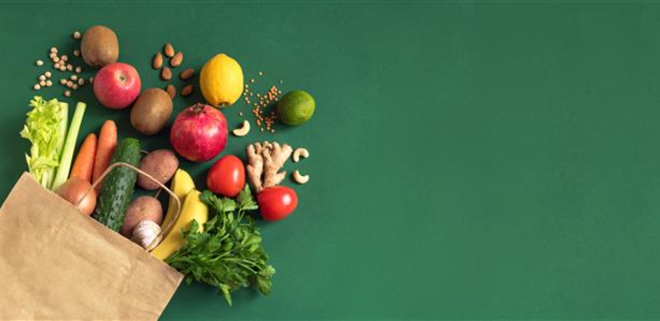 Selection of fruit and vegetables spilling out of a grocery bag