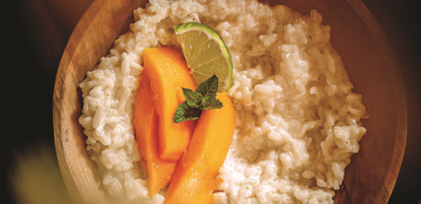 Vegan coconut rice pudding garnished with mango, lime and mint 