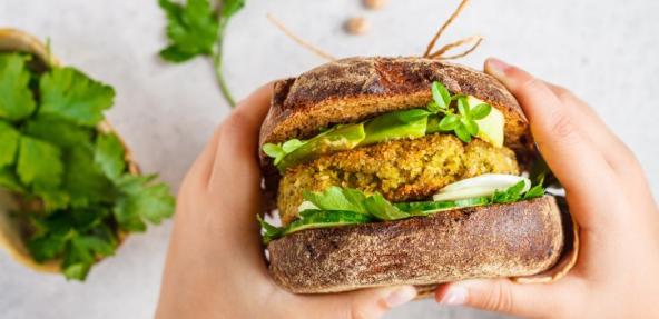 Person holding a vegan burger