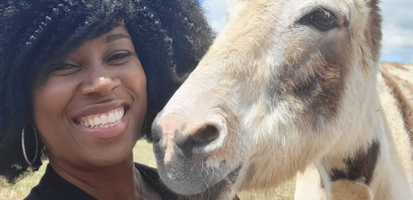 Tabatha James with donkey at an animal sanctuary