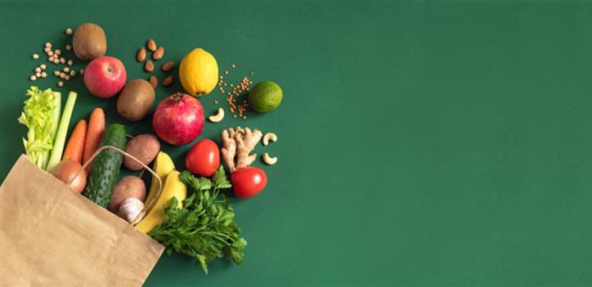 Selection of fruit and vegetables spilling out of a grocery bag