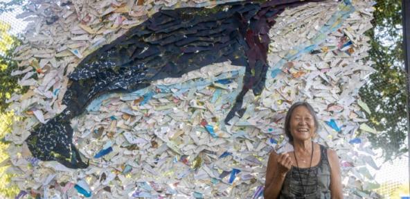 Peggy Oki in front of artwork of whale (Credit Phillip R Lee)