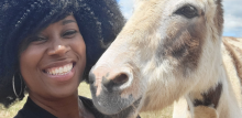 Tabatha James with donkey at an animal sanctuary