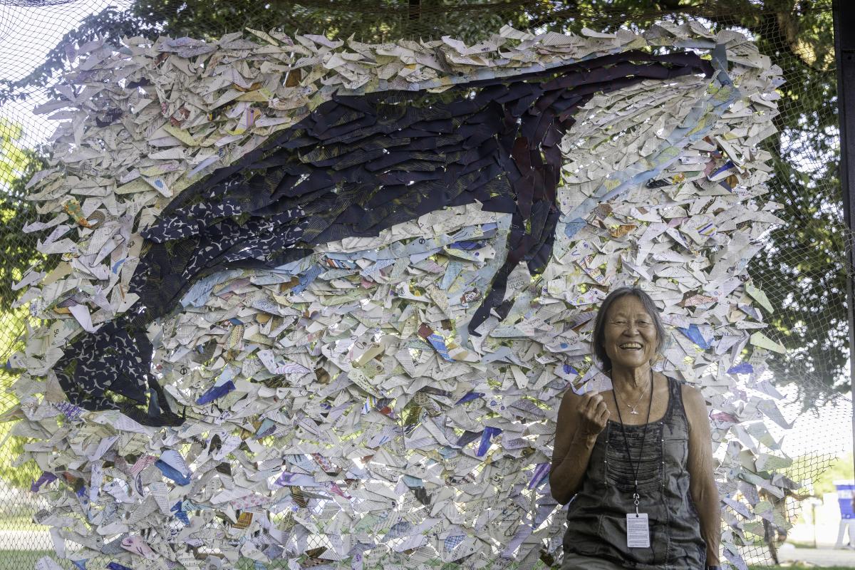 Peggy Oki in front of artwork of whale (Credit Phillip R Lee)